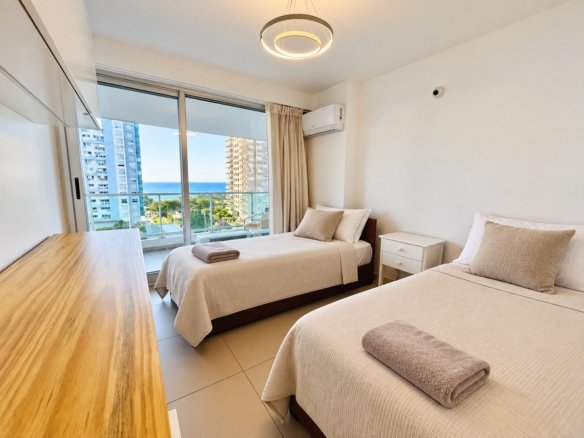 Dormitorio luminoso con dos camas en Gala Tower Playa Mansa