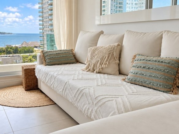 Sofá y living con vista al mar en Gala Tower Playa Mansa